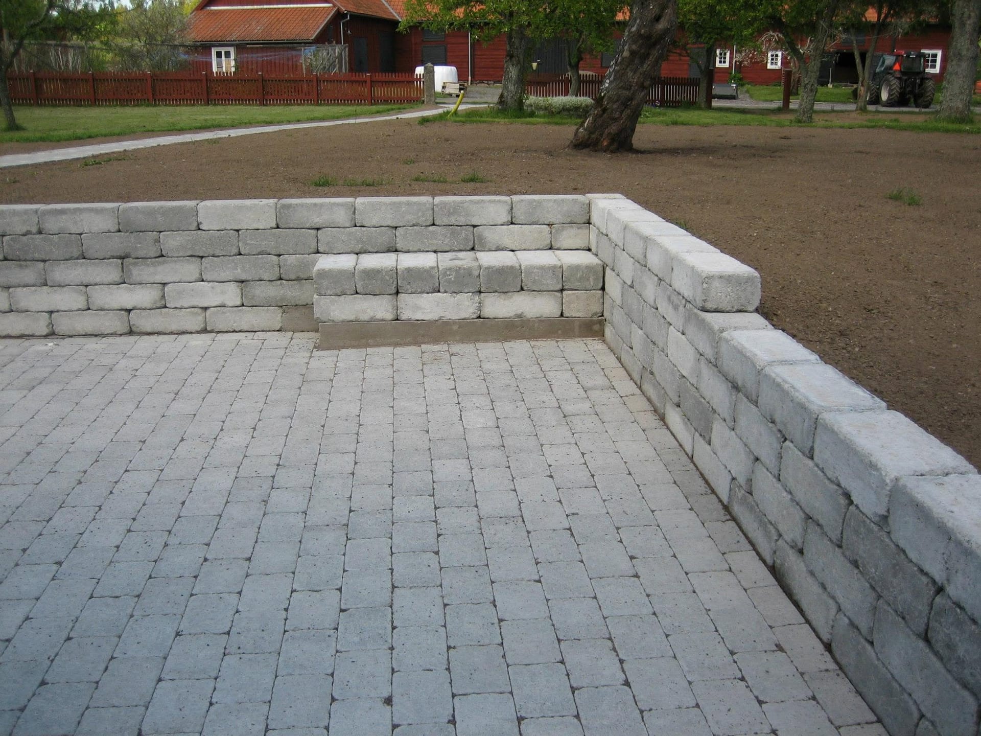 Stenlagd yta med stödmur och inbyggd bänk